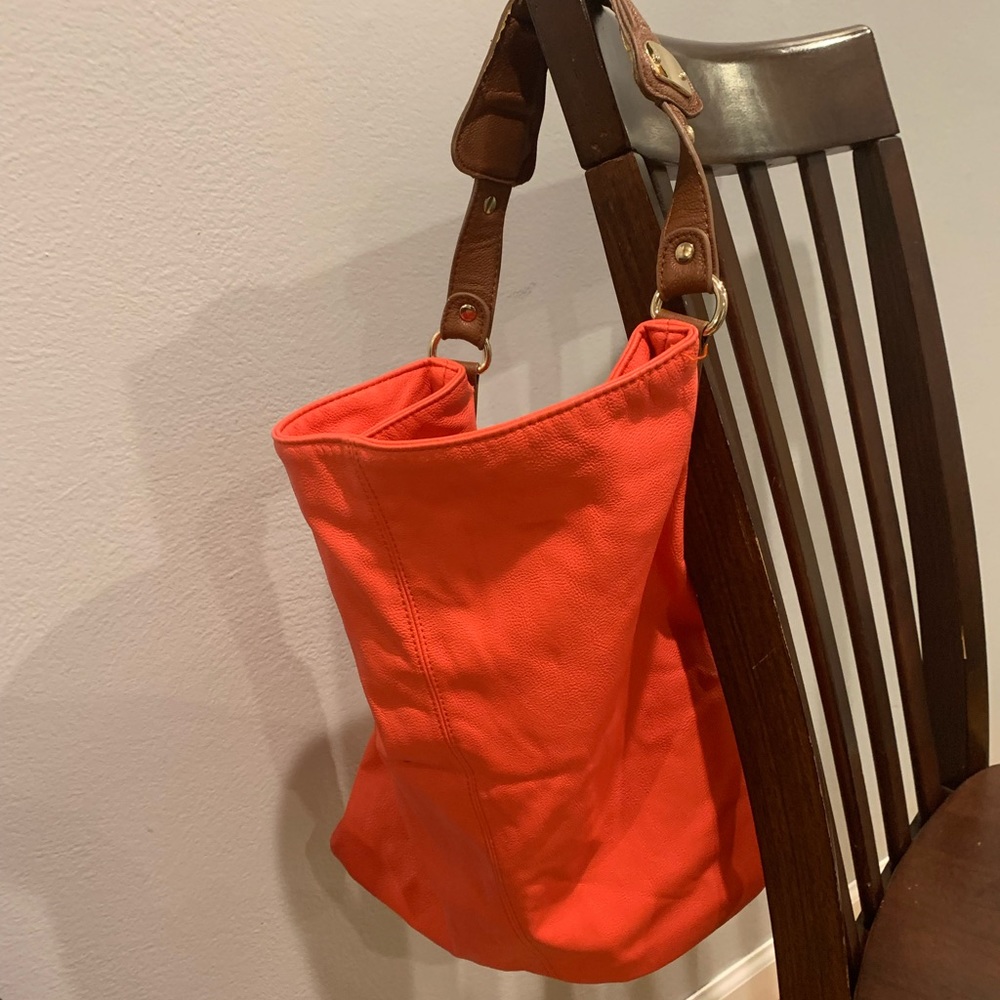Tangerine purse with brown strap and gold accents